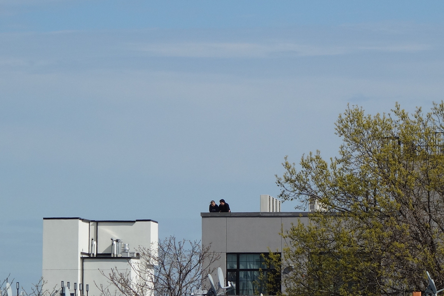 photo of people on rooftop talking on cellphones
